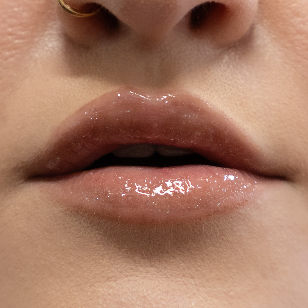 Close-up of a person's lips with a glossy lip product.