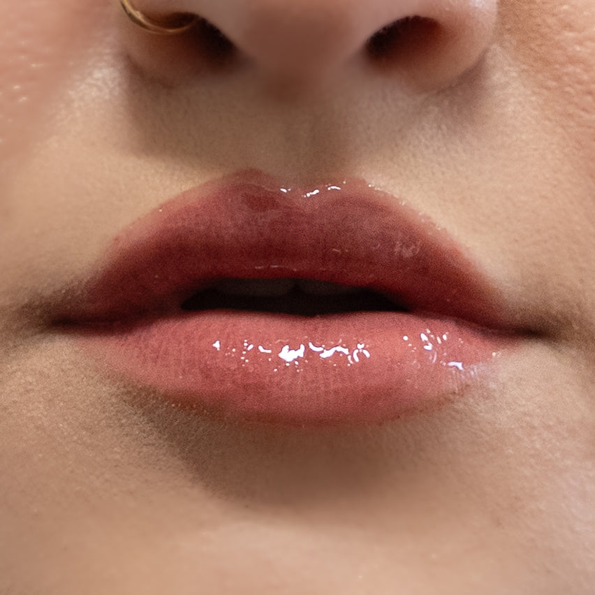 Close-up of glossy pink lips with a blurred background