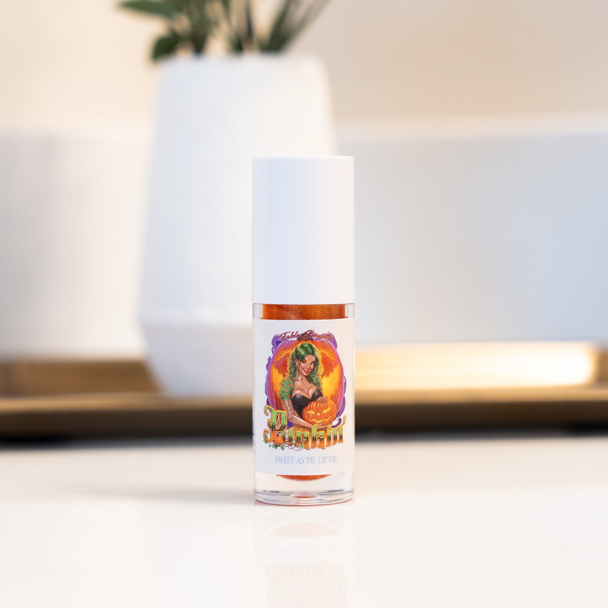 Vial with colorful label featuring a design of a woman on a white surface.