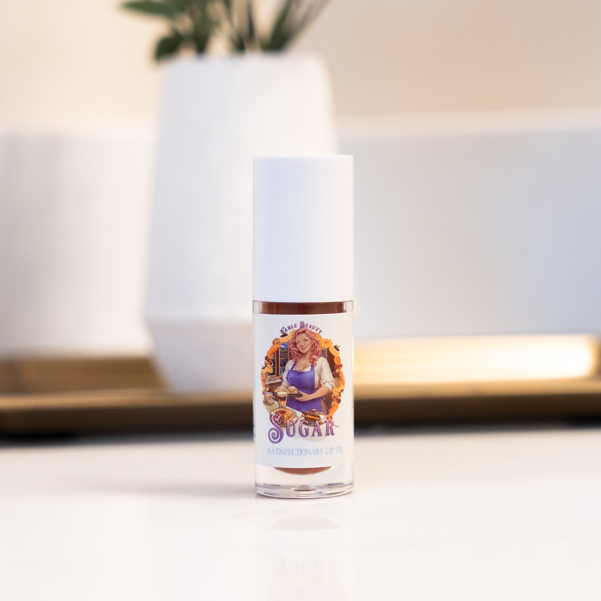 Lip balm with a colorful label featuring a woman on a blurred indoor background