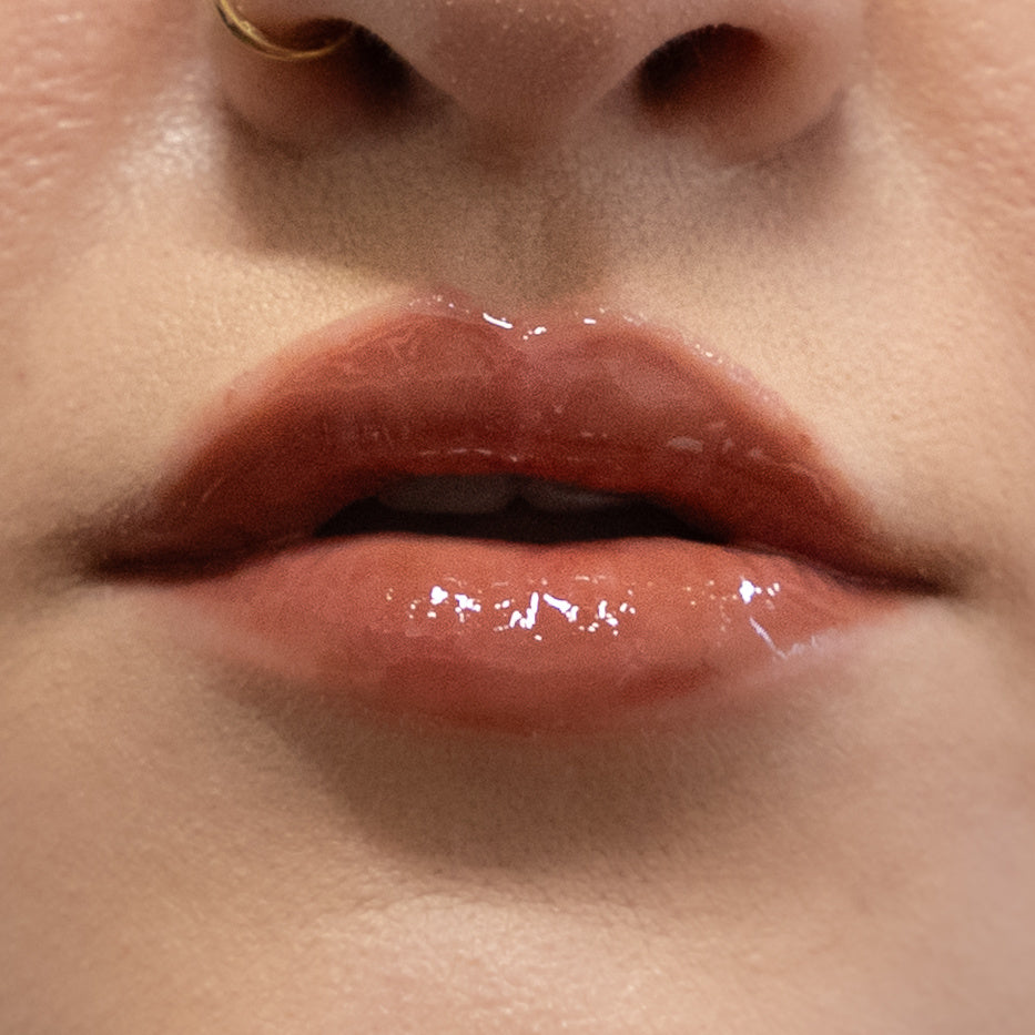 Close-up of glossy lips with a soft focus on skin texture