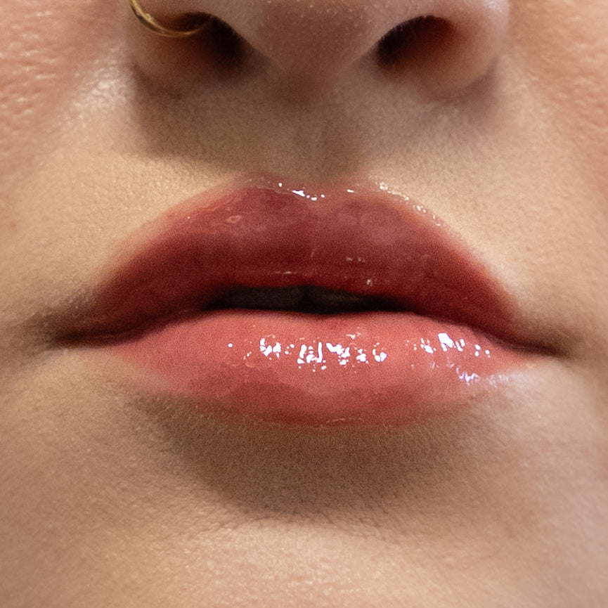 Close-up of glossy pink lips with a blurred background