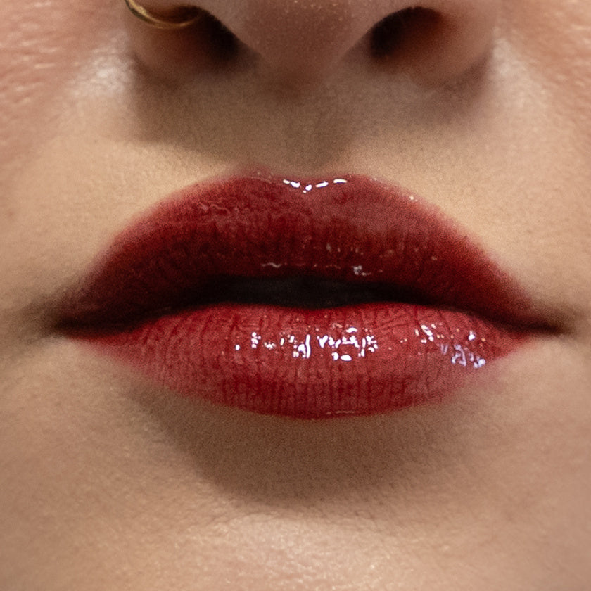 Close-up of glossy red lipstick on lips