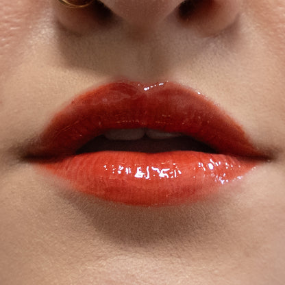 Close-up of glossy red lips with a neutral background