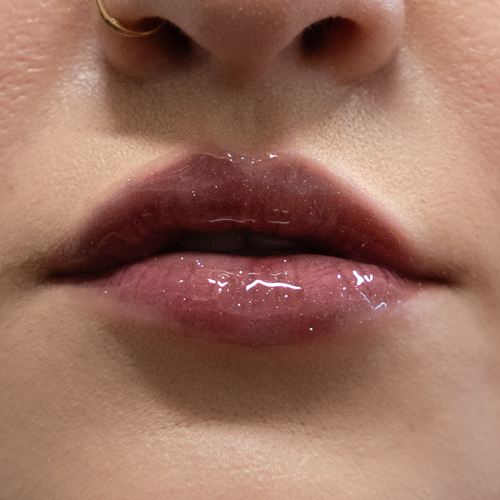 Close-up of glossy pink lips with a neutral background