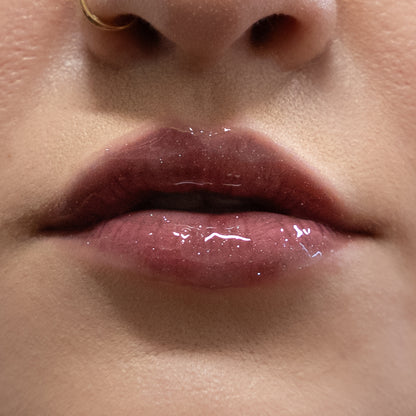 Close-up of glossy pink lips with a neutral background